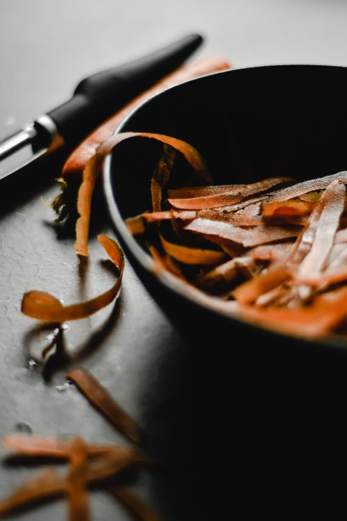 Free Stylish close-up of carrot peels in a black bowl, perfect for kitchen or culinary themes. Stock Photo