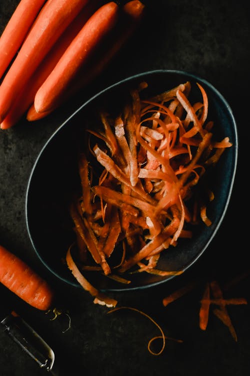 Close Up of Peeled Carrots and Peels in Bowl