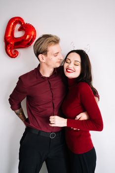 年轻夫妇拥抱心形气球，象征着爱情与亲情，构成了完美的浪漫主题