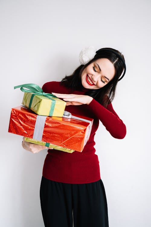 Woman in Red Long Sleeve Shirt Carrying Boxes of Gifts