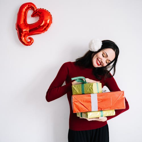 A Smiling Woman Carrying Boxes of Gifts
