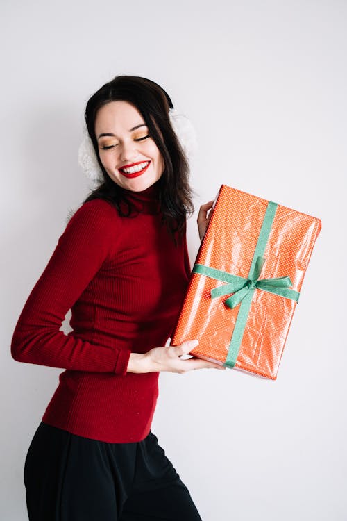 Free Woman Smiling while Holding a Gift Box Stock Photo