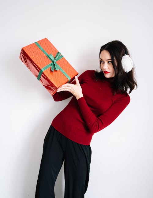 A Woman Holding a Red Gift Box with a Green Ribbon