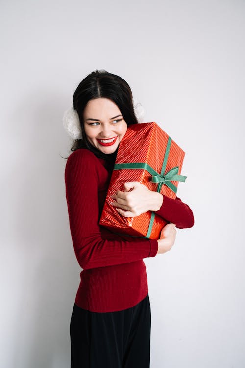 A Woman Smiling while Hugging a Gift Box