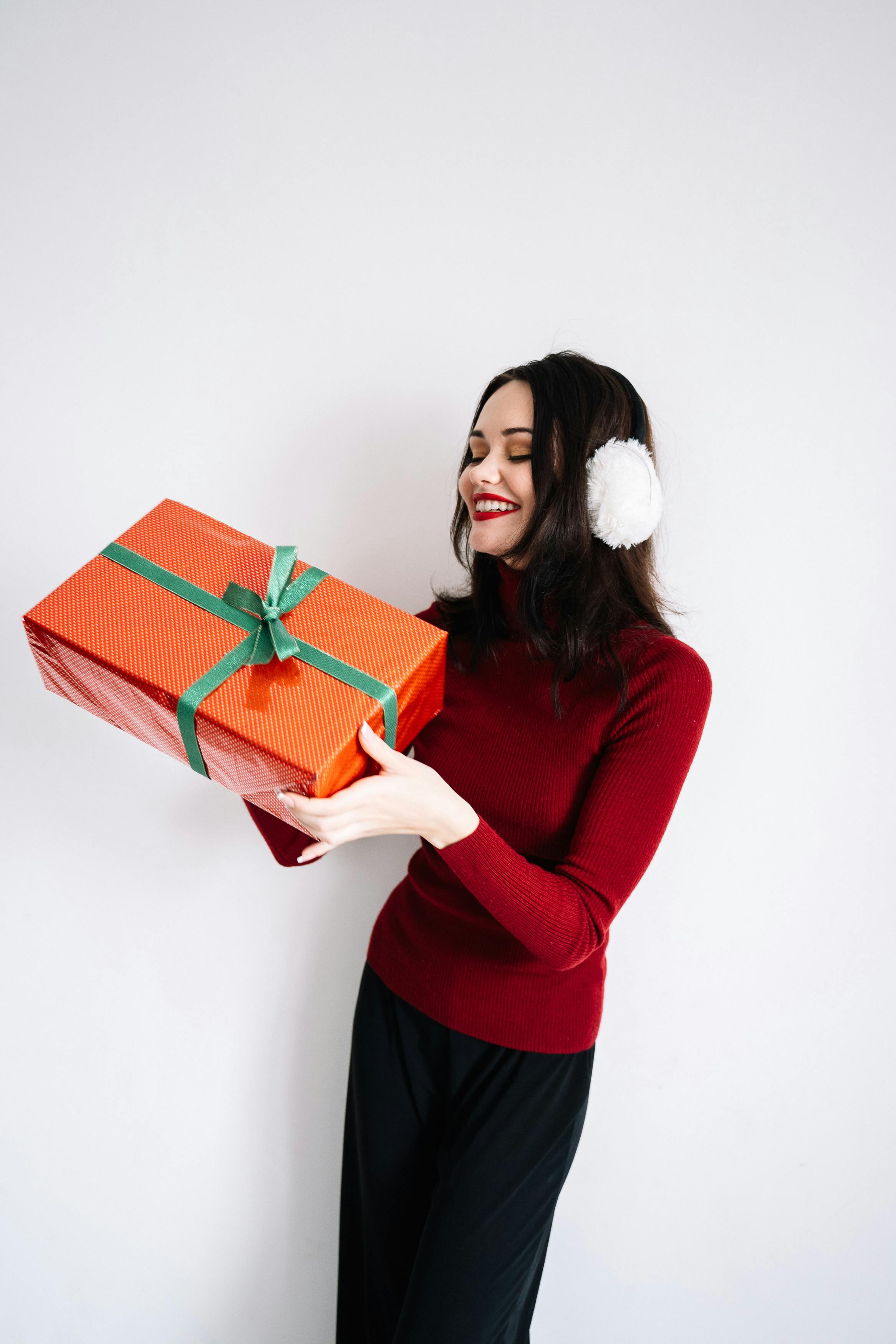 a woman smiling while holding a box