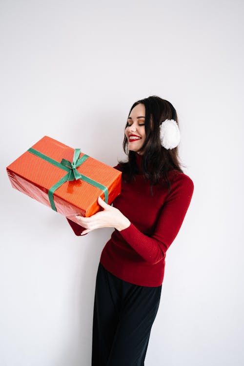 Free A Woman Smiling while Holding a Box Stock Photo
