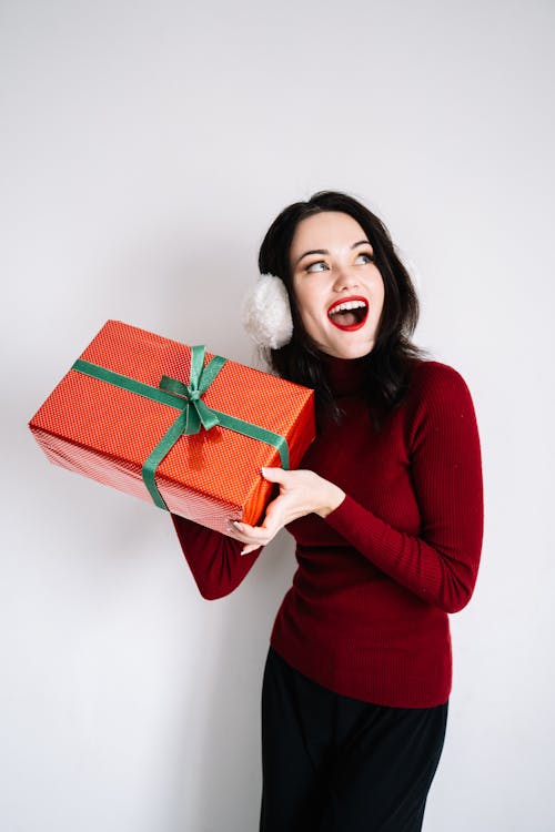 Woman in Red Long Sleeved Shirt Holding a Gift Box