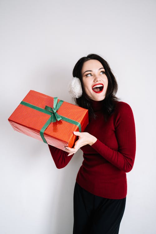 Woman in Red Long Sleeved Shirt Holding a Gift Box