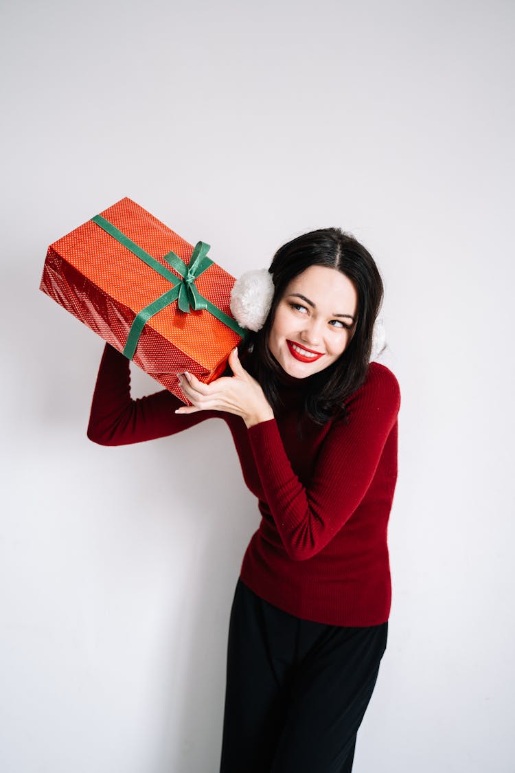 Woman In Red Long Sleeve Shirt Holding A Red Gift Box