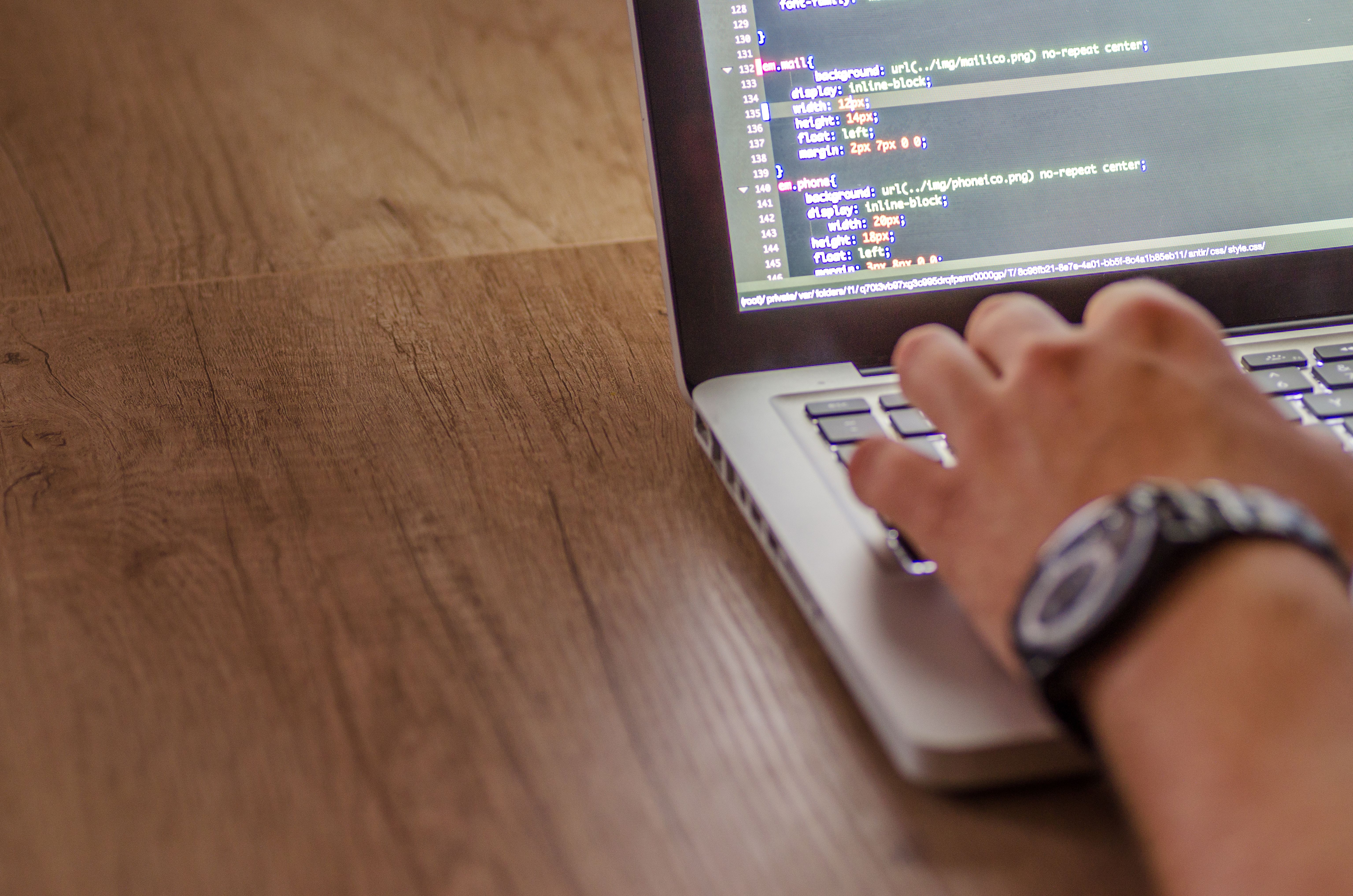 Close-up of a person, with a laptop on the desk, reflecting a focused and productive workspace.