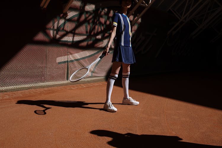 A Girl In Blue Active Wear Playing Tennis