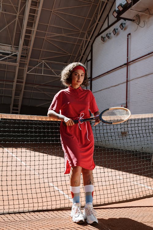 Donna In Camicia Bianca A Maniche Lunghe E Gonna Rossa Che Tiene La Racchetta Da Tennis