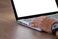 用笔记本电脑的空白屏幕拍摄的手部特写，非常适合添加自定义内容