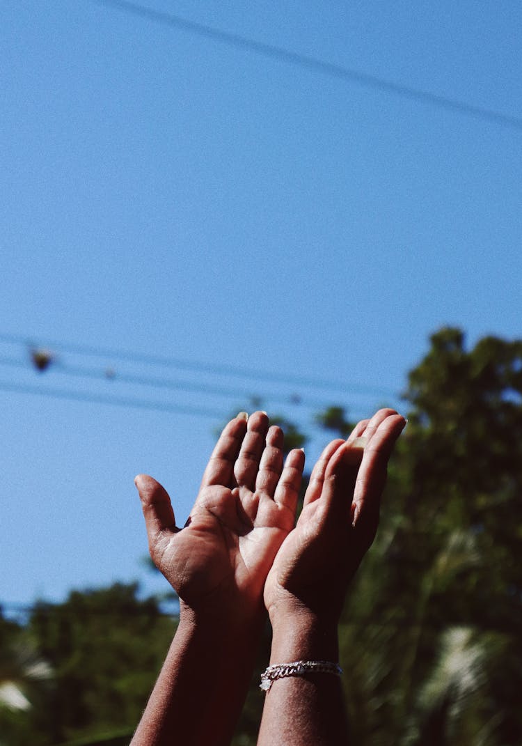 A Person Lifting It's Hands On The Sky