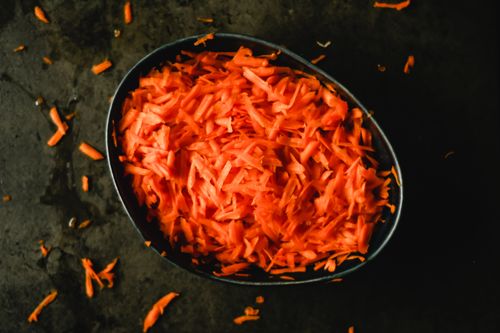 Free Top view of metal baking pan filled with grated fresh carrot prepared for cooking in kitchen Stock Photo