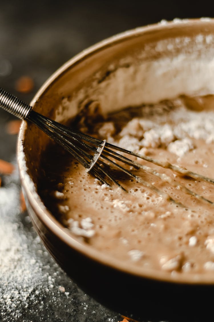 A Whisk And Batter In A Bowl