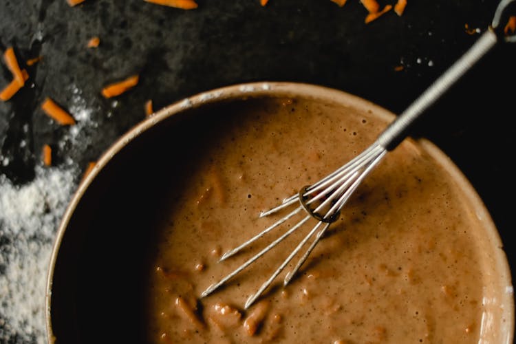 A Whisk And Batter In A Bowl