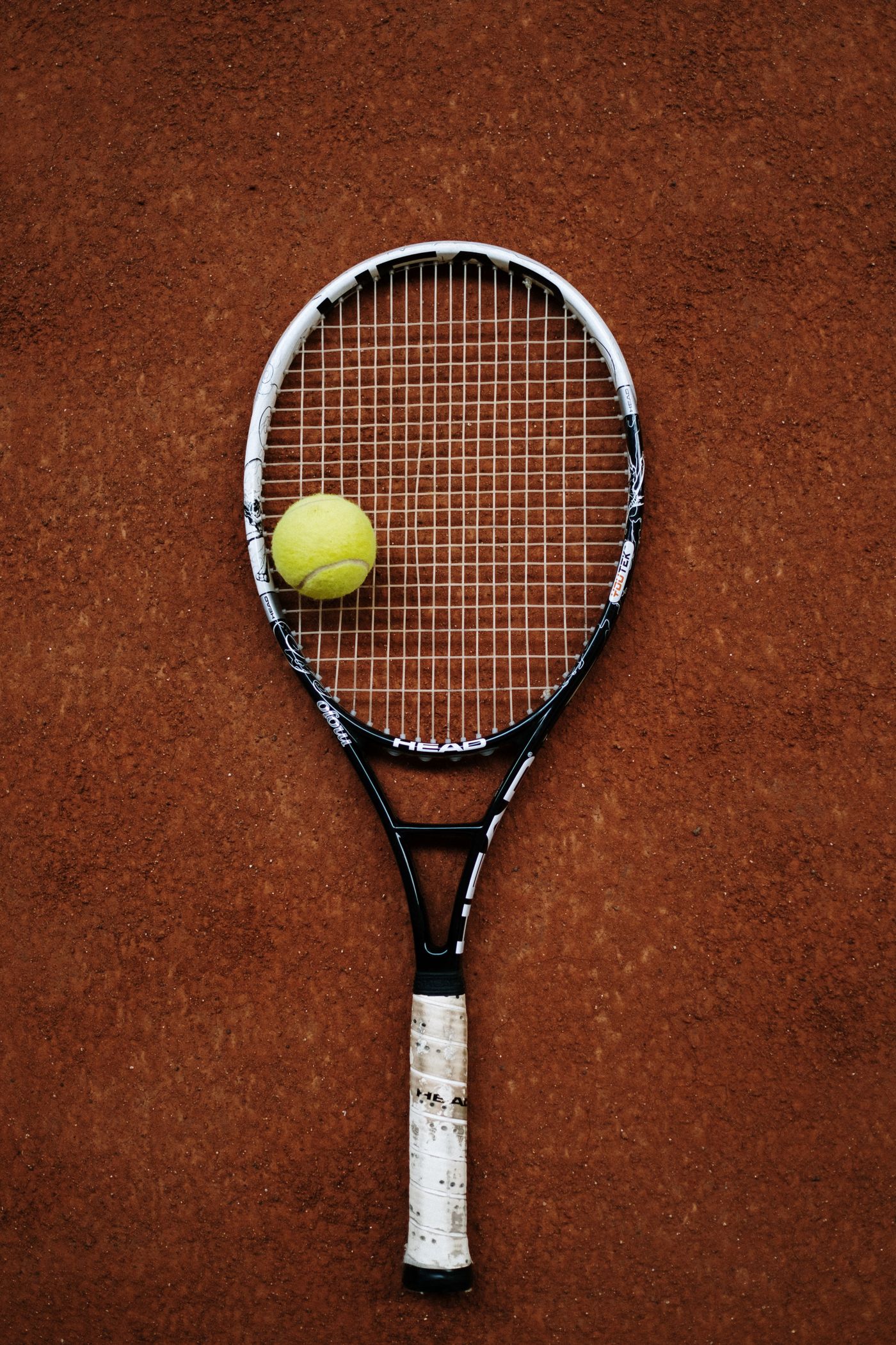 Tennis racket and balls on a clay court