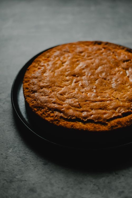 Free Delicious homemade carrot cake displayed on a black plate, perfect dessert presentation. Stock Photo