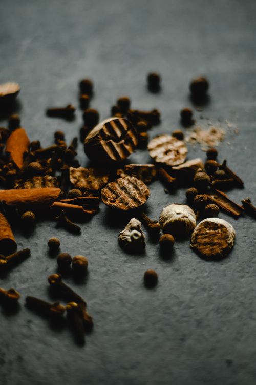 Free A collection of spices spread across a dark countertop, creating a rich, earthy composition. Stock Photo