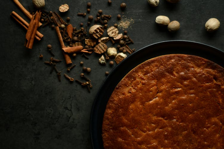 Dried Herbs And Spices Near A Brown Pie 