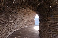 探索这个独特的弧形木制结构，它拥有自然编织的设计和开放的空间