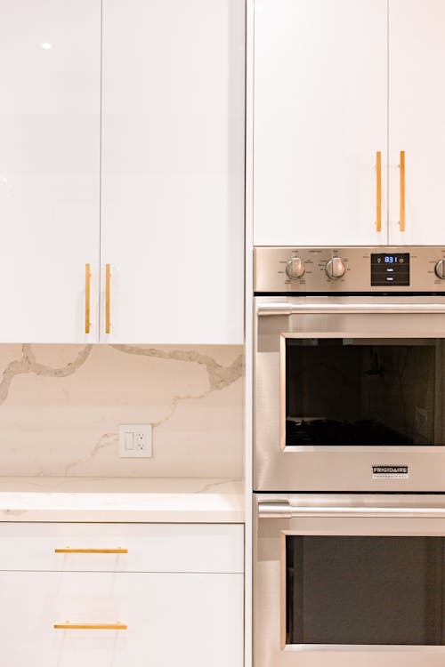 Kitchen interior with white cupboards and ovens