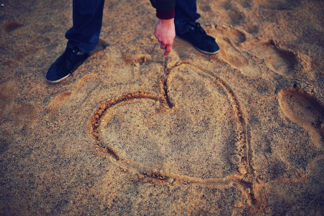 Free Hand drawing heart in the sand Stock Photo