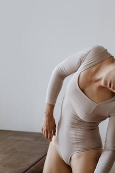 一个人身着米色紧身衣，长袖搭在木桌上，整体色调简约而温暖