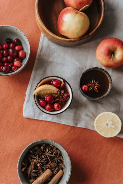 Free Warm flat lay of mulled wine ingredients with apples, cranberries, and spices. Stock Photo