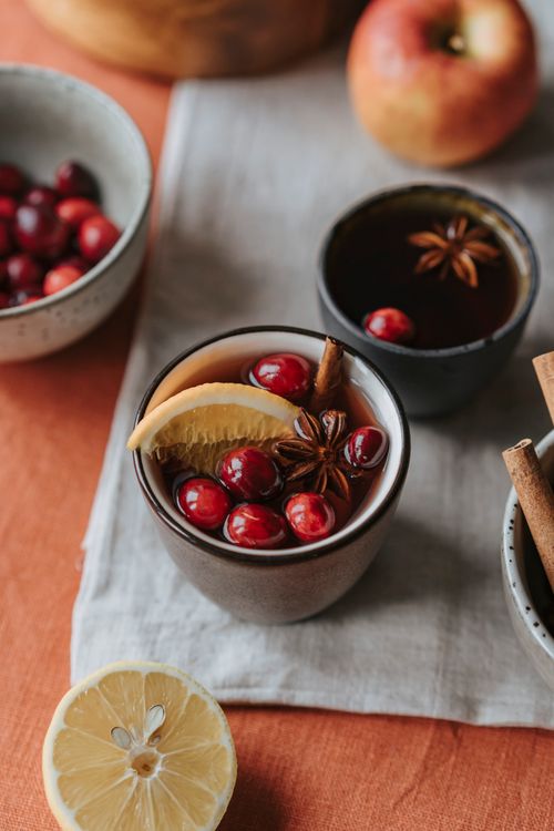 Free Cozy mulled wine with cranberries, star anise, and lemon wedge, perfect for warm gatherings. Stock Photo