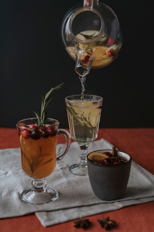Free Warm mulled wine in glass cups with fresh fruits and spices, perfect for a cozy winter evening. Stock Photo