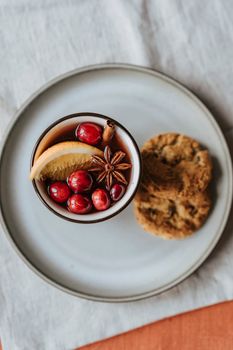 盘子里放着温暖诱人的甜酒，配以蔓越莓、香料和饼干