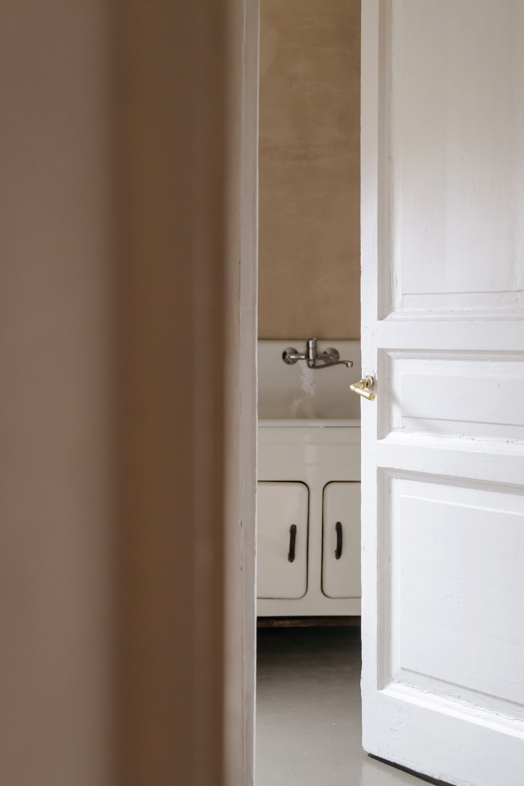View into a bathroom through a partially open white entry door