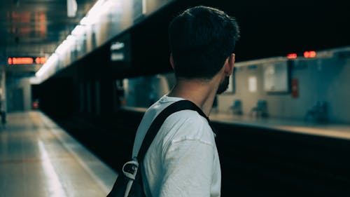 Man in White Shirt With Black Backpack