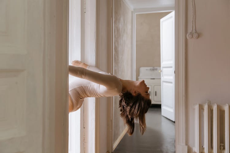 Woman Holding On The Door Casing While  Leaning Backward 