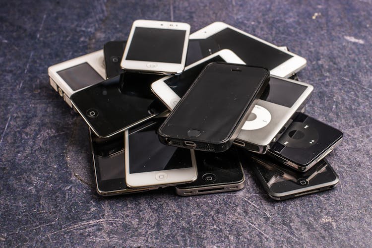 Heap Of Old Smartphones And Media Players On Grunge Surface