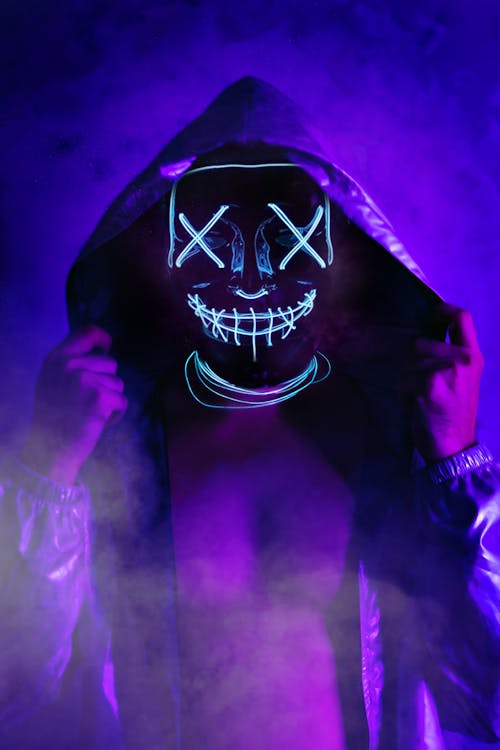 A Bright Blue Neon Light in a Shape of a Mask Photographed in Smoke ...