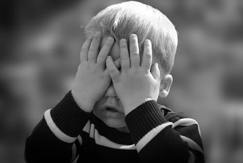 Free Boy in Black and White Sweater Covering His Face With His Tow Hand Stock Photo