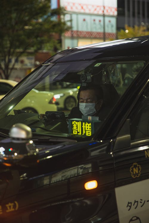 Asian man wearing mask in car