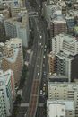 Aerial view of modern city with multistory buildings and wide roadway full of transport