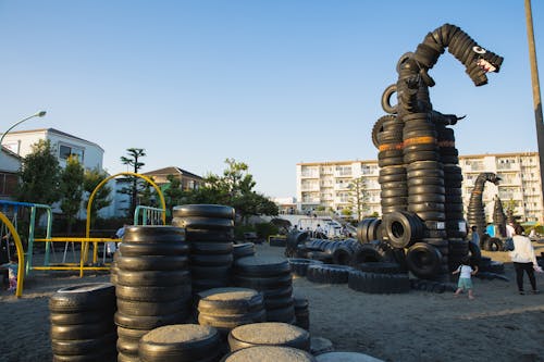 Suburb yard playground with stacks of old tyres constructed in huge monster creature