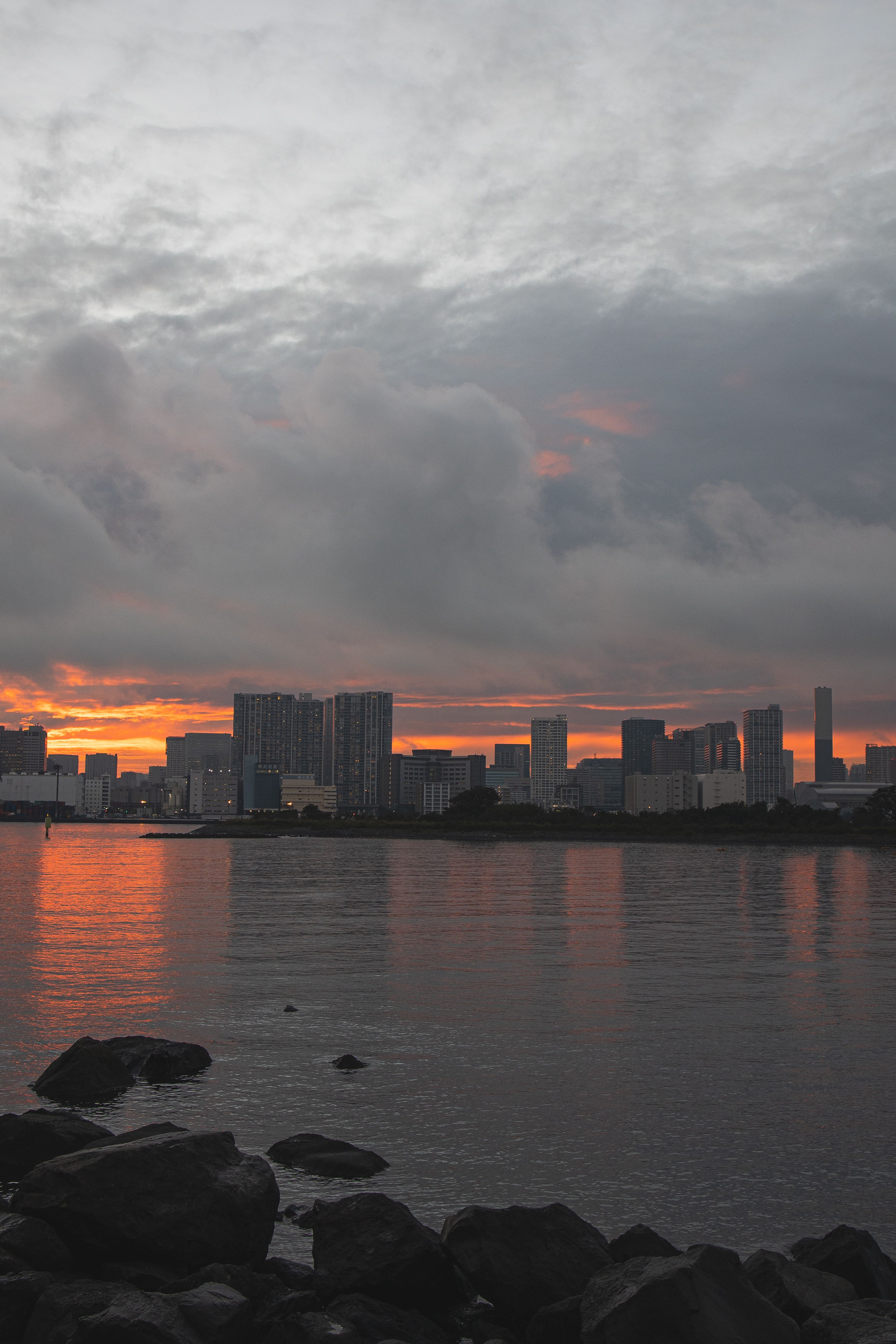 日落时分，东京天际线如画的景色倒映在海湾上，展现了现代建筑的魅力