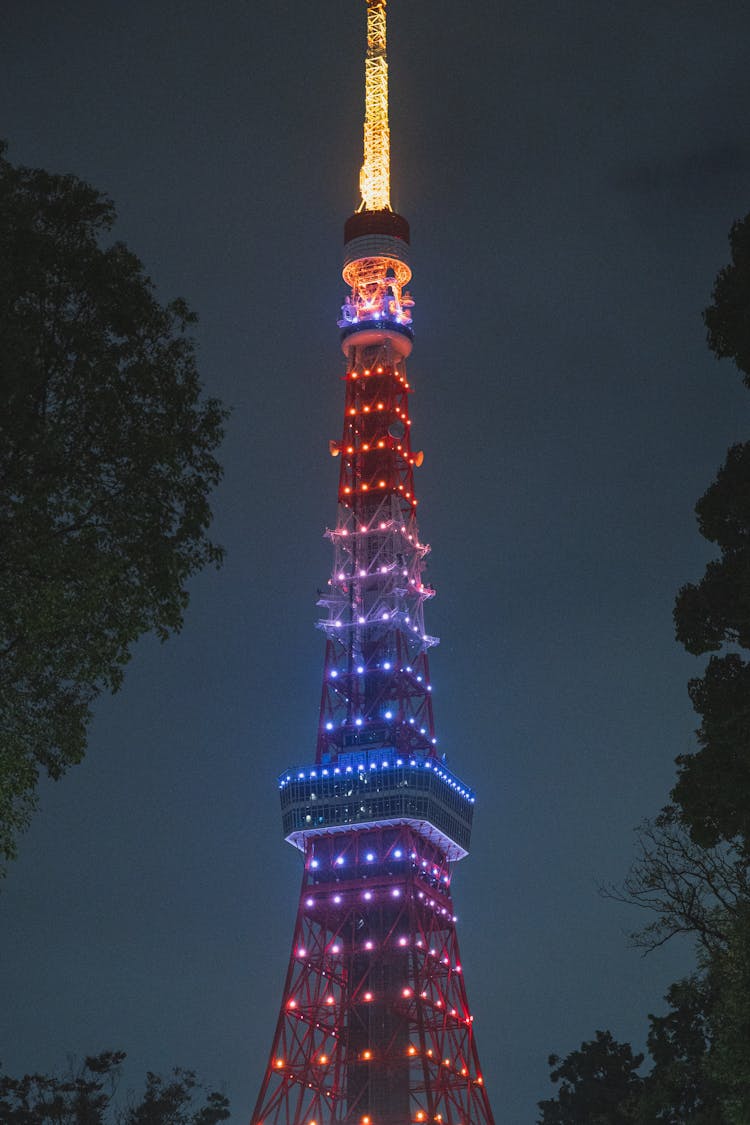 Illuminated Television Tower In Modern City At Night