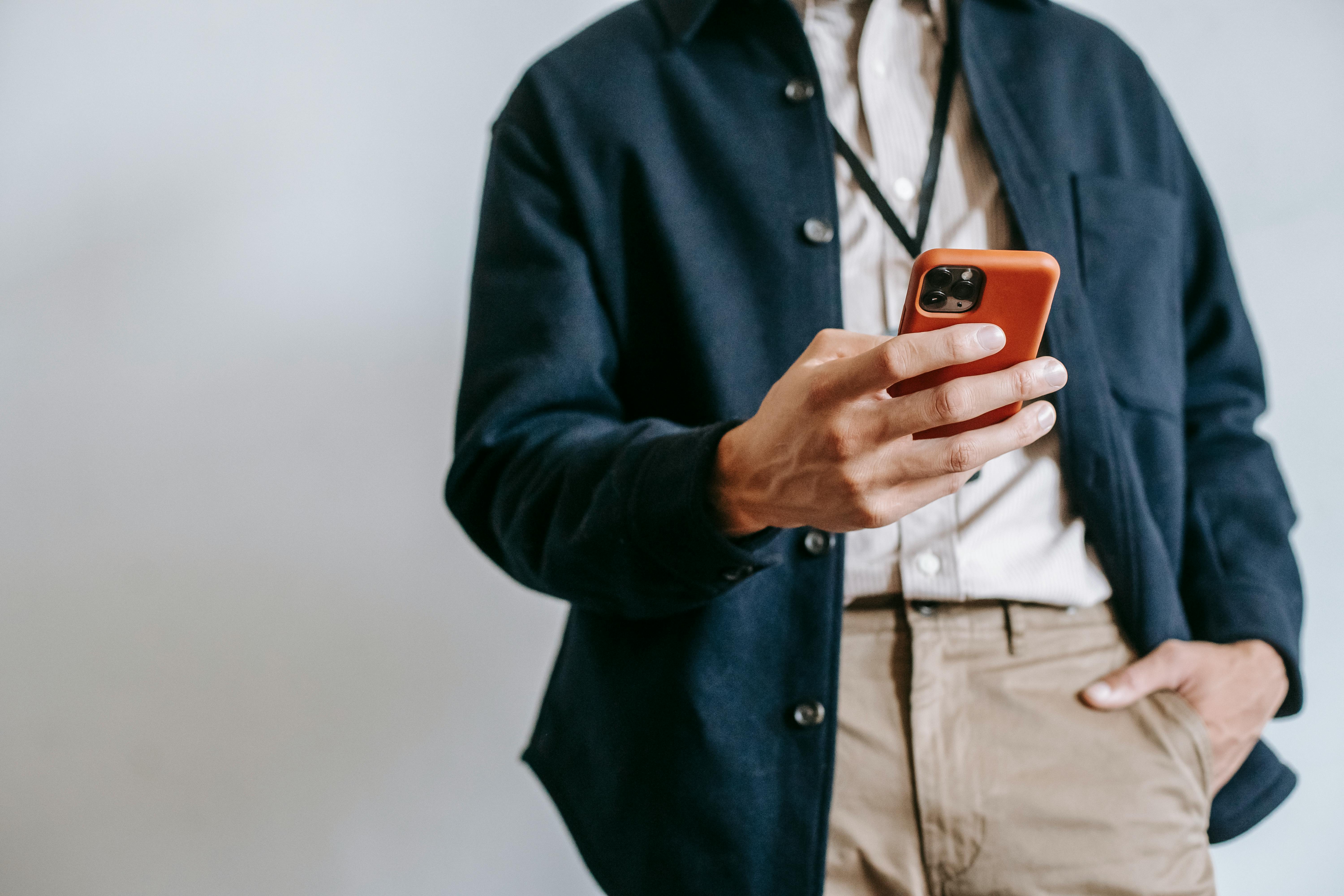 faceless male entrepreneur using smartphone against white background