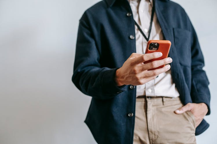 Faceless Male Entrepreneur Using Smartphone Against White Background