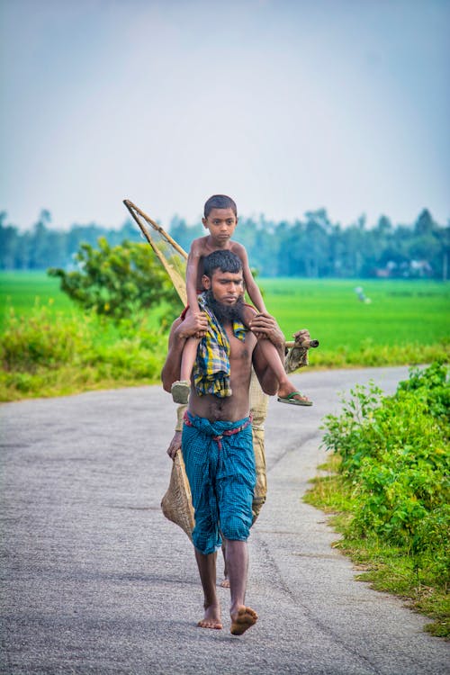 Man Carrying His Son While Walking