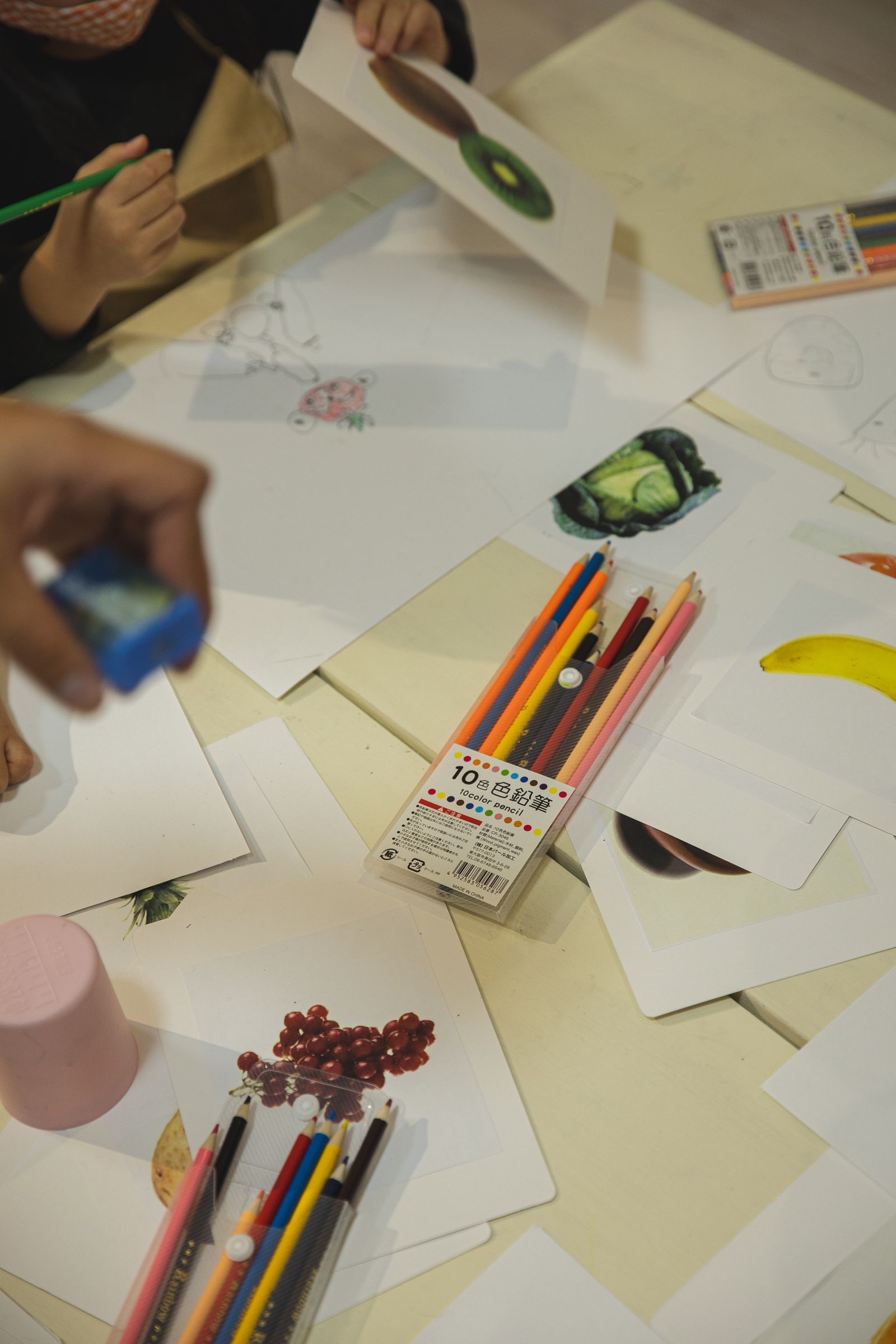 Children drawing with colored pencils on paper during a hands-on creative education activity