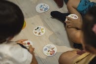 Crop group of ethnic children playing game with illustrated cards