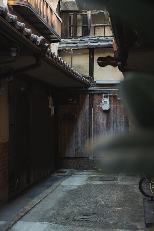 Empty footpath between aged dwelling buildings in city